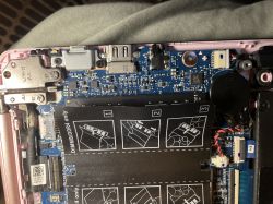 Wnętrze laptopa z widoczną płytą główną, portami i złączem USB-C; zbliżenie na elementy elektroniczne.