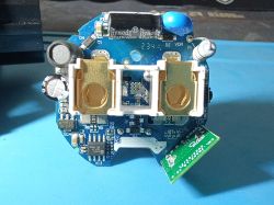 PCB with two gold sockets and surface-mount components Close-up of a blue PCB with electronic components and two gold sockets in a white frame