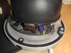 Wnętrze urządzenia elektronicznego z widocznym fragmentem płytki PCB i komponentami.