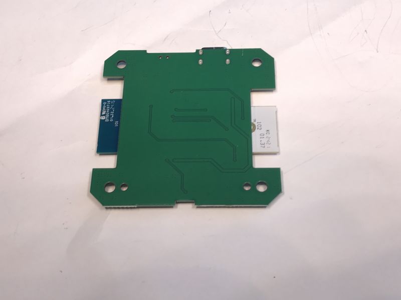 Green electronic module with visible traces on a white background.