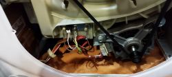 Wnętrze pralko-suszarki Whirlpool GWDG86148BPL pokazujące przewody elektryczne i części mechaniczne.