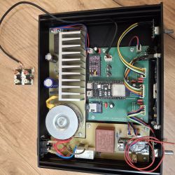 Interior of a hand-built electronic device with PCB, wiring, and components