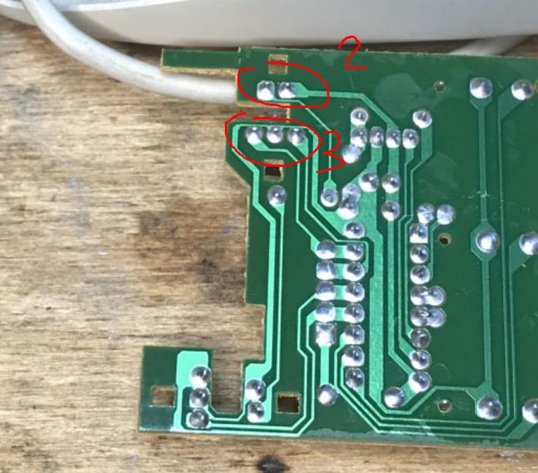 Printed Circuit Board from Inside Old Computer Mice Printed circuit board with exposed tracks and soldered connections.