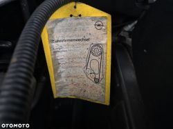 Opel timing belt replacement tag attached in engine bay.
