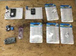 Breadboards with connected electronic modules on a wooden table.