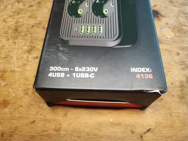 Dolny róg kartonu z opisem produktu: listwa zasilająca 8x230V, 4 porty USB i 1 port USB-C, długość przewodu 300 cm.