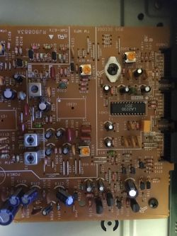 Fragment płytki drukowanej z elementami elektronicznymi, takimi jak kondensatory, rezystory i układy scalone.