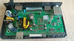 Wnętrze urządzenia: płytka PCB z wieloma kondensatorami elektrolitycznymi i żółtym transformatorem
