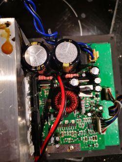 Wnętrze subwoofera Monacor Sound - 100sub z widocznymi elementami elektronicznymi i ciemnym nalotem.