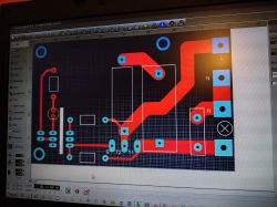 Projekt płytki PCB z czerwonymi ścieżkami i oznaczeniami L oraz N na ekranie komputera