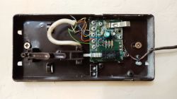 Wnętrze starego domofonu z podłączonymi kolorowymi przewodami do płytki PCB