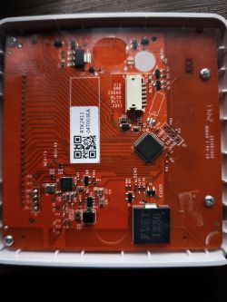 Close-up of a red PCB with electronic components and connectors in a plastic case.