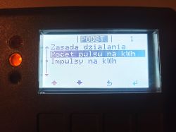 Wyświetlacz falownika Fronius pokazuje opcję „Poczet impulsu na kWh” w menu ustawień