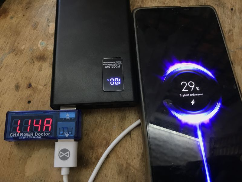 BY-K7 power bank charges smartphone via QC, showing 29% and 1.14 A on display