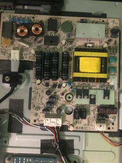 Zdjęcie wnętrza telewizora z widoczną płytą główną i komponentami elektronicznymi.