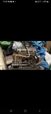 Silnik parowy Lipsia z widoczną rurką i kołem zamachowym na stole roboczym.