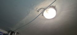 Kabel elektryczny luźno wiszący pod sufitem obok lampy.