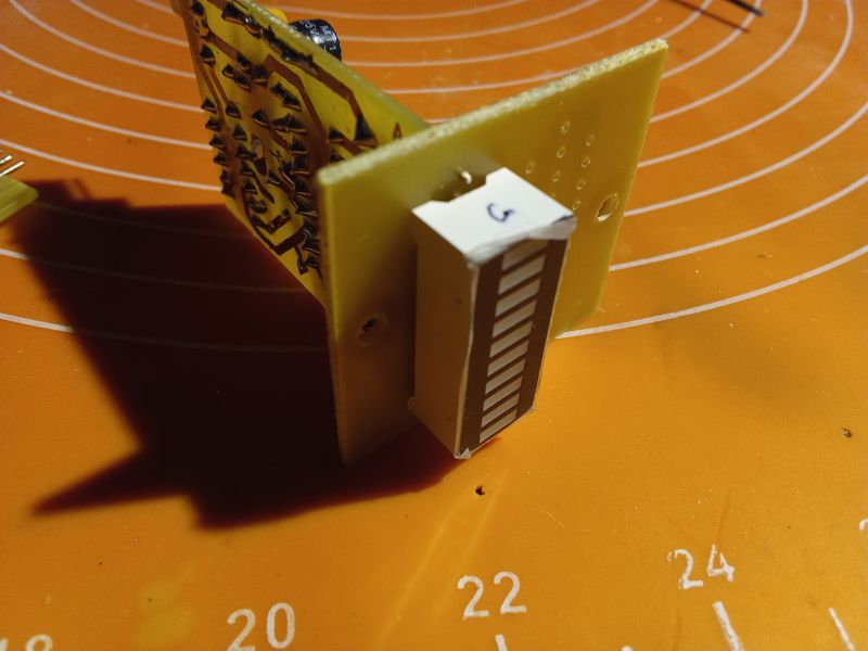 LED display on a PCB on an orange work mat.