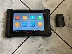 Tablet diagnostyczny AUTEL z ekranem menu oraz moduł VCI obok na kafelkowanej podłodze