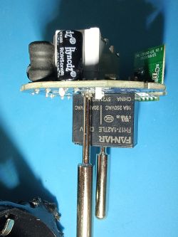 Electronics module with relay and temperature probe PCB module with FJH17-1A21LE relay, electrolytic capacitor, and metal temperature probe on a blue mat