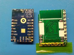 Two small PCB modules side by side on a blue surface, showing solder pads and pin labels