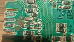 Zbliżenie na płytkę PCB z widocznymi nadpaleniami i uszkodzeniem ścieżek