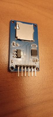 Electronic module with an SD card slot and several components on a circuit board.