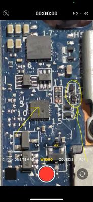 Zbliżenie na płytkę PCB z uszkodzonymi elementami elektronicznymi, z żółtymi oznaczeniami wskazującymi potencjalne wypalenia lub uszkodzenia.