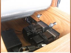 Zdjęcie dwóch silników elektrycznych umieszczonych pod drewnianą obudową maszyny.