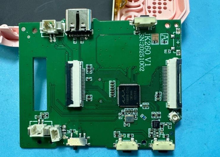 Green PCB with a USB‑C port, ribbon connectors, and a central integrated circuit on a blue background