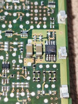 Zbliżenie na płytę PCB z układem scalonym oznaczonym jako 2025 i elementami SMD.