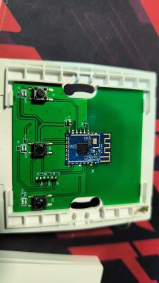 PCB in a white case with three tactile switches and a blue module with a printed antenna