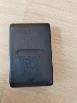 Czarny akumulator z napisem BATTERY PACK na drewnianej powierzchni.