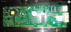 Zielona płytka PCB z podzespołami elektronicznymi, kondensatorami i cewką.