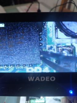 Close-up of a display showing an image of an electronic circuit board, with the label WADEO visible.