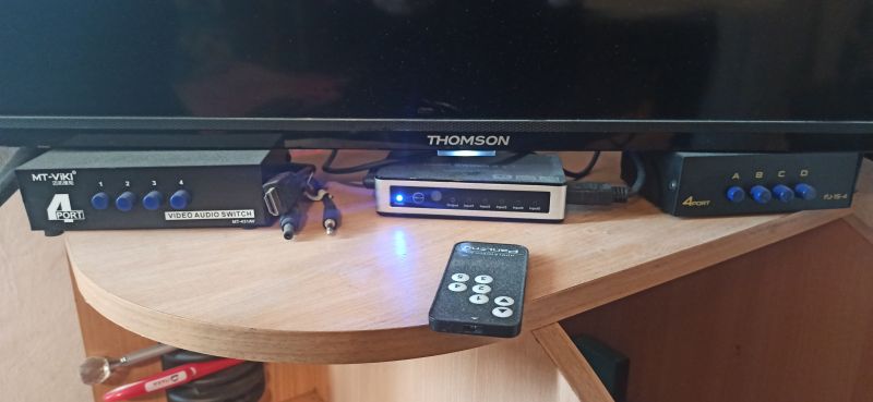Przełączniki audio-wideo na stoliku przed telewizorem Thomson.