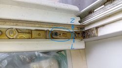 Zdjęcie mechanizmu okna z elementami regulacyjnymi zaznaczone niebieskim okręgiem.