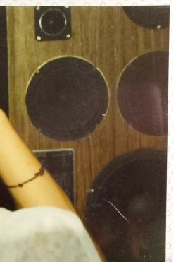 Fragment starej, domowej kolumny głośnikowej z kilkoma widocznymi przetwornikami na drewnianej obudowie.