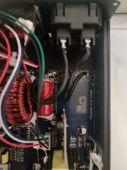 Widok wnętrza przetwornicy DC12V/AC230V z widocznymi przewodami i elementami elektronicznymi.