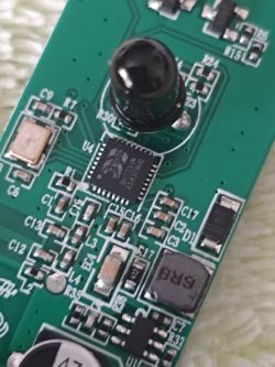 Close-up of a PCB with a black sensor lens, an IC chip, and multiple SMD components