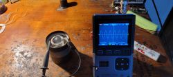 DSO-TC4 oscilloscope connected to an acoustic transducer on a wooden workbench