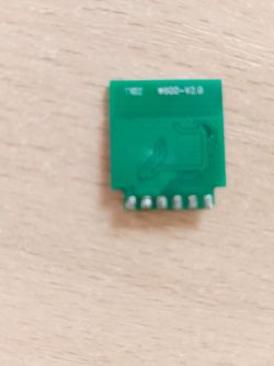 Close-up of a small green PCB with markings on top.
