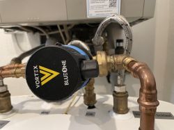 Vortex BlueOne water pump connected to a plumbing system under a boiler.