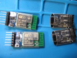 DX-WF24 BLE5.2 Modules and USB-TTL Converters on Board Two DX-WF24 BLE5.2 modules and two USB-TTL converters on a blue work surface.
