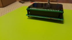 Close-up of a display module mounted on a green connector board.