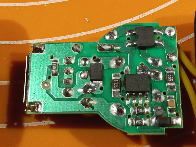 Płytka PCB ładowarki z widocznymi elementami elektronicznymi i lutami.