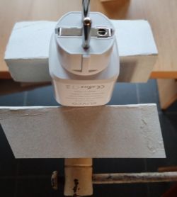 Electric Plug in Vise Electric plug placed between two wooden boards.