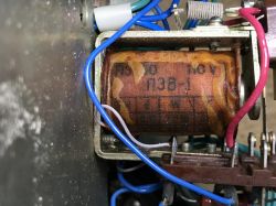 Close-up of a coil inside a device, labeled “110V”, with blue and red wires attached
