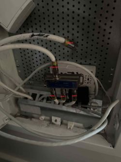Splitter antenowy z kilkoma podłączonymi kablami w skrzynce multimedialnej