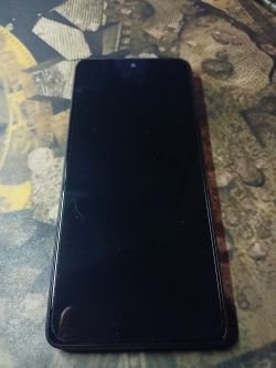 Smartfon z czarnym ekranem leżący na wzorzystym tle